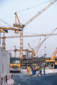Active construction site with towering cranes and workers in hard hats, illustrating construction accident cases handled by Aulsbrook Car & Truck Wreck Injury Lawyers Arlington