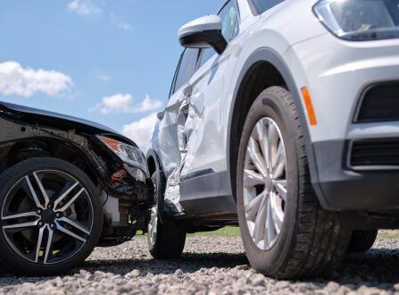 Black car and white SUV with crash damage after a collision, representing car accident cases handled by Aulsbrook Car & Truck Wreck Injury Lawyers Fort Worth