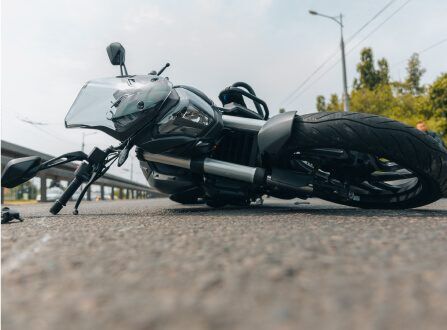 Motorcycle lying on its side in the roadway after a crash, illustrating the motorcycle accident cases handled by Aulsbrook Car & Truck Wreck Injury Lawyers Fort Worth